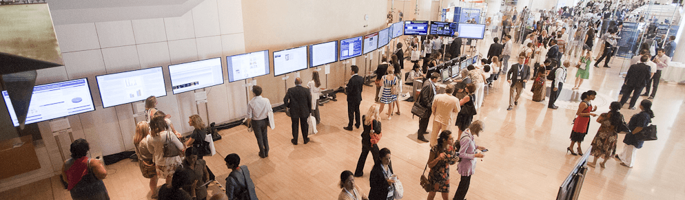 Attendees viewing ePoster displays on a busy conference floor